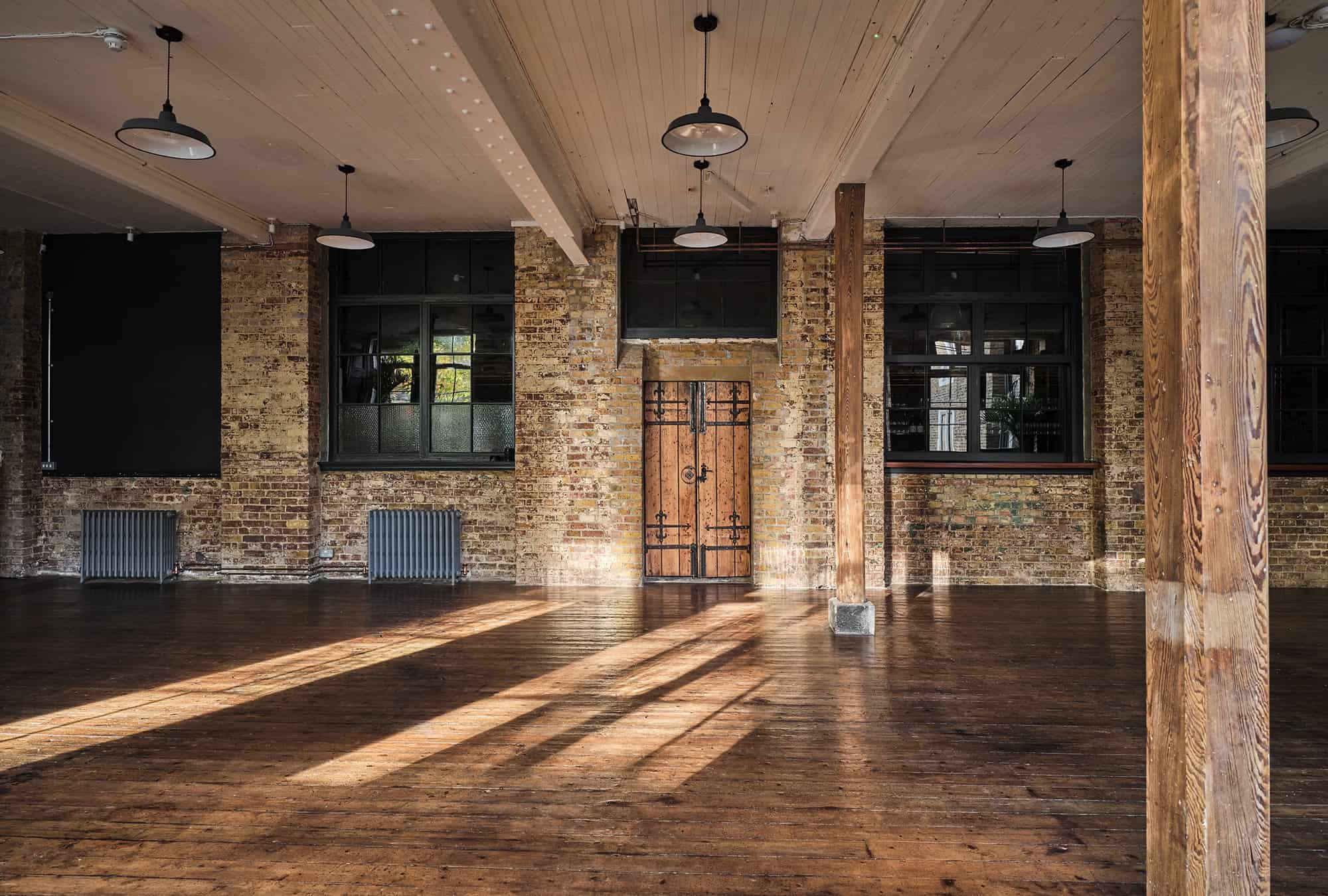 The hall: timber columns, bare brick and afternoon light